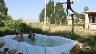Yüksekova'da Çocuklar Sıcaklardan Korunmak İçin Branda Havuzlarda Serinliyor